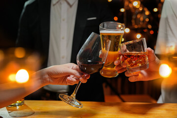 food and drink male friends are happy drinking beer and clinking glasses at a bar or pub.