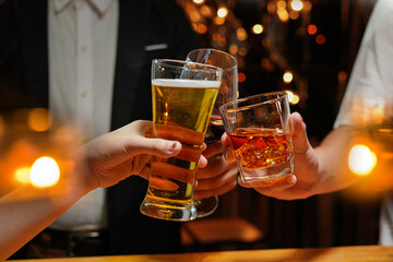 food and drink male friends are happy drinking beer and clinking glasses at a bar or pub.