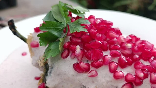 Parsley and pomegranate on a Mexican chile en nogada