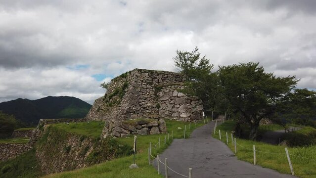 Walkway leading up to takeda castle ruins in asago japan, overcast day overlooking lush green valley