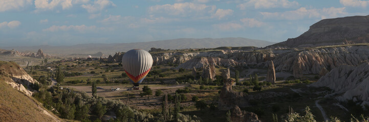 One hot air balloon over fairy chimneys and valley in Cappadocia, Turkey.