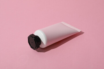 Pink tube with cream on pink background