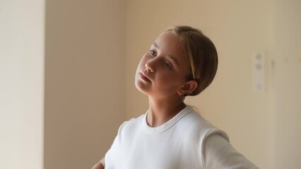 Closeup of cute little child girl doing workout with stretch muscle neck at home. Pretty kid girl practicing exercise doing yoga for relax with sport, motivation and determined for health, slow motion