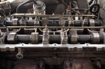Fototapeta na wymiar Cylinder head and camshaft. Gasoline engine repair. Engine valve cover.