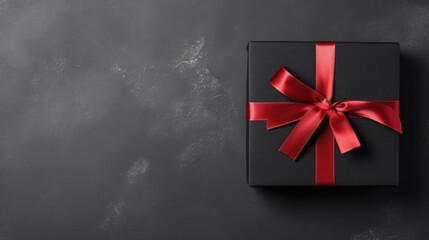 Black gift box with red ribbon on black background. Top view.