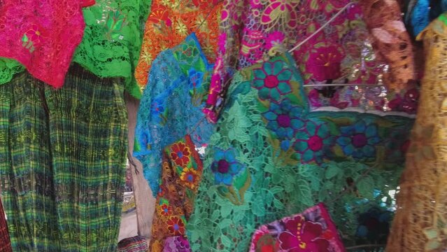 Pan across colorful lace clothing in Central American street market