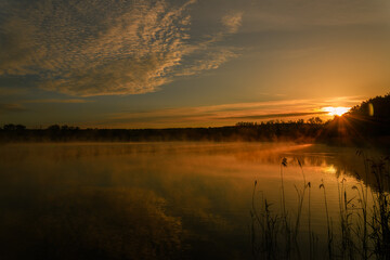 colorfull sunrise over pond with mist