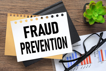 Fraud prevention page on black notepad. financial charts