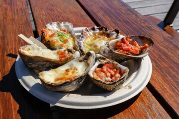 A plate of grilled oysters with assorted toppings (garlic cheese, mornay, bacon) at Jim Wilds Oyster Shack, Greenwell Point, NSW