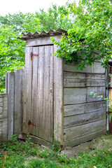 An old wooden toilet in the village. Rustic toilet outside the premises.