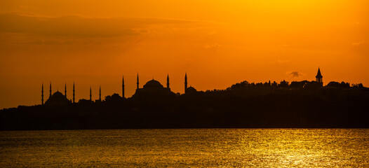 Eminonu city with mosque silhouettes in the background at sunset