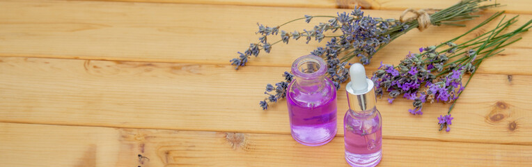 Obraz na płótnie Canvas lavender essential oil, on a wooden background. Selective focus