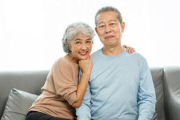 Blissful moments, elderly asian husband and wife sharing joy on sofa, timeless romance, heartwarming moments, peaceful harmony, timeless togetherness, happy family couple, grey hair