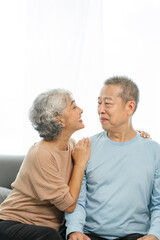 Blissful moments, elderly asian husband and wife sharing joy on sofa, timeless romance, heartwarming moments, peaceful harmony, timeless togetherness, happy family couple, grey hair