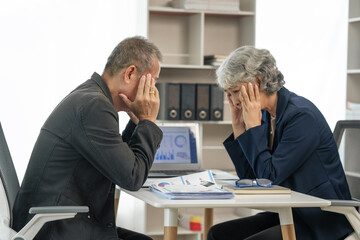 Stressed senior businessman and businesswoman suffering financial crisis, headache, fail.