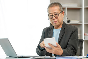 Mature businessman diligently working at his office desk, demonstrating dedication and commitment to his tasks. Experienced executive, Corporate competence, Executive commitment, Business maturity