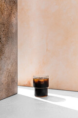 Refreshing iced  cold black coffee in a glass in a ray of light with copy space - 645217932
