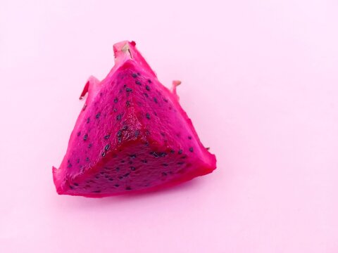 dragon fruit. Slices of fresh red dragon fruit on a pink background.
