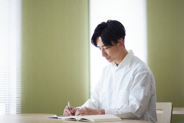 大学の図書室で勉強をする日本人大学生の男性