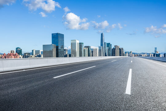 Fototapeta Asphalt highway road and city skyline with modern buildings