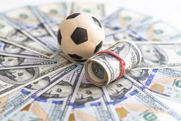 Soccer ball on dollar banknotes, closeup. Betting on sport concept 