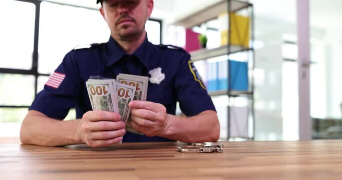 Police officer counts dollars at police station at workplace. Police corruption system