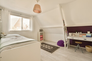a bedroom with a bed, desk and window in the attic style home that has been used for many years