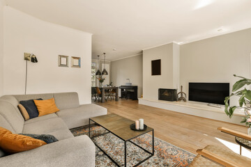 a living room with a couch, coffee table, and television on the wall in the room is very clean
