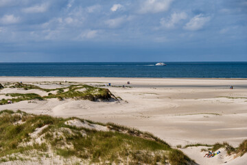 Fototapeta na wymiar Dünenlandschaft auf der Nordseeinsel Amrum mit Blick auf die Nordsee, ein Fahrgastschiff fährt vorbei