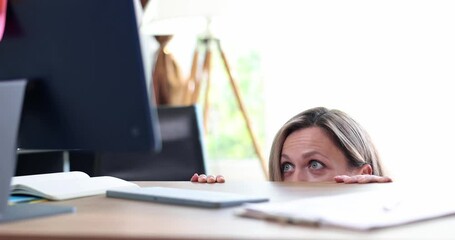Frightened and shocked woman looks at computer screen in panic. Getting bad news and watching scary movie