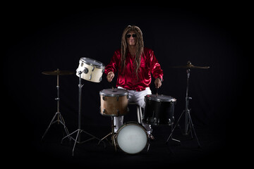 Fototapeta na wymiar male drummer plays drums on a black background