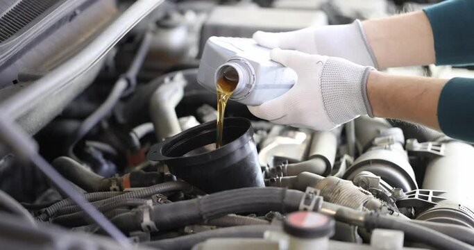 Mechanic fills car engine with engine oils. Car service