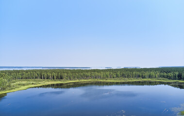 Aerial photo of forest boggy lake in the Karakansky pine forest near the shore of the Ob reservoir.