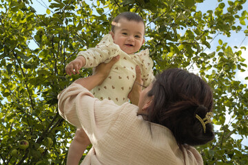 Importance of Outdoor Play. mom and her infant playing airplane on a lawn, this photo exemplifies the vital role that outdoor activities have in a child s early development and bonding.