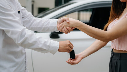 Automotive business, car sale or rental concept Customer with car dealer agent making deal and signing on agreement document contract in auto showroom.