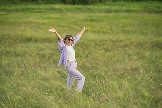 Senior woman, at ease in nature with wildflowers, showcasing the tranquility achievable with secure financial planning