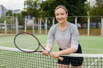 Portrait of young smiling woman professional female tennis player in uniform.