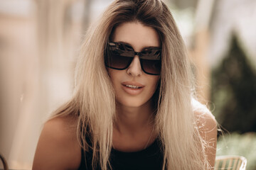 Beautiful blonde female model in sunglasses, close-up portrait