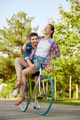 Adventures together. Couple in love riding one bicycle. Handsome guy with laughing woman travel. Lovely riders enjoying themselves on trip.