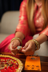 Closeup shot of hands of woman holding Rakhi