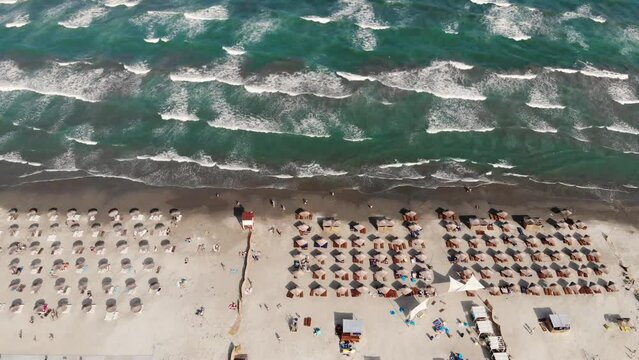 Flying over the Navodari beach panning up into the Black sea on a sunny day