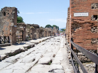 Stone paved road and footpath, with stepping stones to cross the road avoiding excrement and water, in a street in Pompeii, Italy