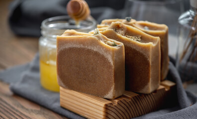 Pieces of natural honey soap handmade on a wooden soap dish. Beautiful atmospheric postcard