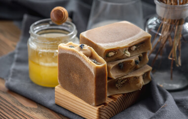 Pieces of natural honey soap handmade on a wooden soap dish. Beautiful atmospheric postcard
