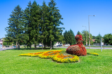 Outdoor flower peacock in Lenti, Hungary - peacock sculpture made of red flowers