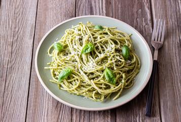 Spaghetti pasta with pesto, basil and Parmesan cheese. Italian cuisine. Vegetarian food.