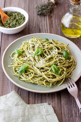 Spaghetti pasta with pesto, basil and Parmesan cheese. Italian cuisine. Vegetarian food.