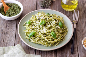 Spaghetti pasta with pesto, basil and Parmesan cheese. Italian cuisine. Vegetarian food.