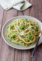 Spaghetti pasta with pesto, basil and Parmesan cheese. Italian cuisine. Vegetarian food.