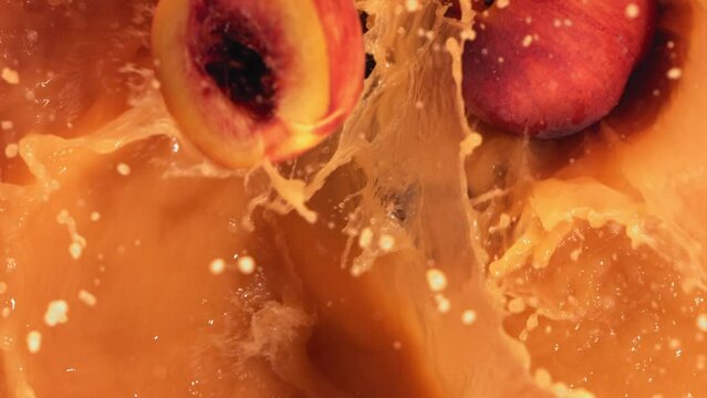 Super Slow Motion Shot of Fresh Peaches Falling into Juice Whirl